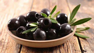 Black Olives In A Ceramic Bowl On Wooden Table