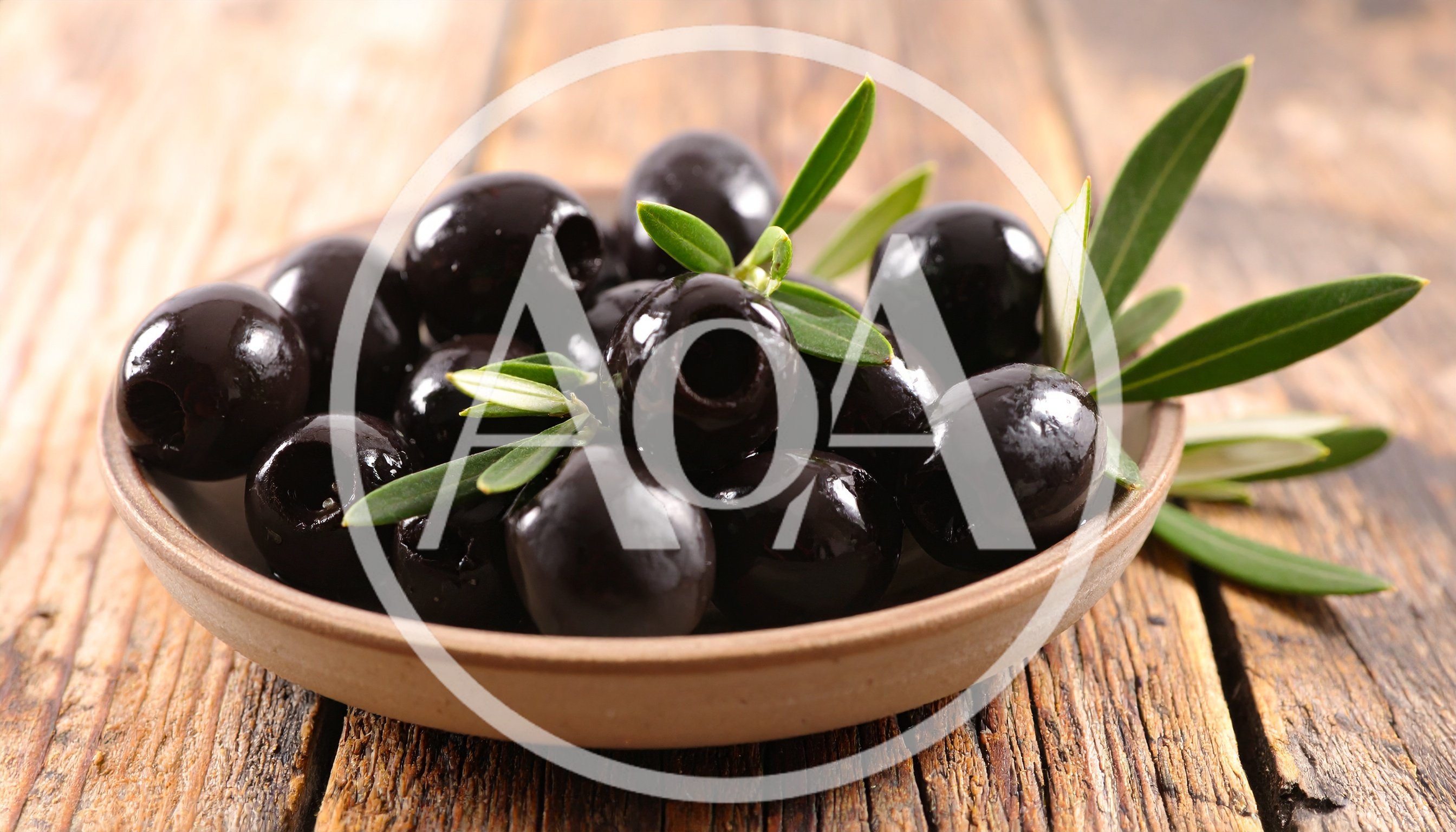 Black Olives In A Ceramic Bowl On Wooden Table