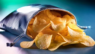 Potato Chips Spilling From A Metallic Foil Bag
