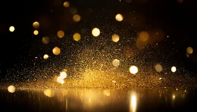 Golden Glitter Particles Exploding On Reflective Surface