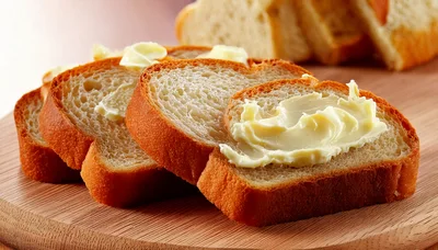 Slices Of Fresh Bread With Butter On Wooden Board