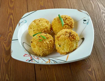 Four Golden Fried Potato Croquettes On A Plate