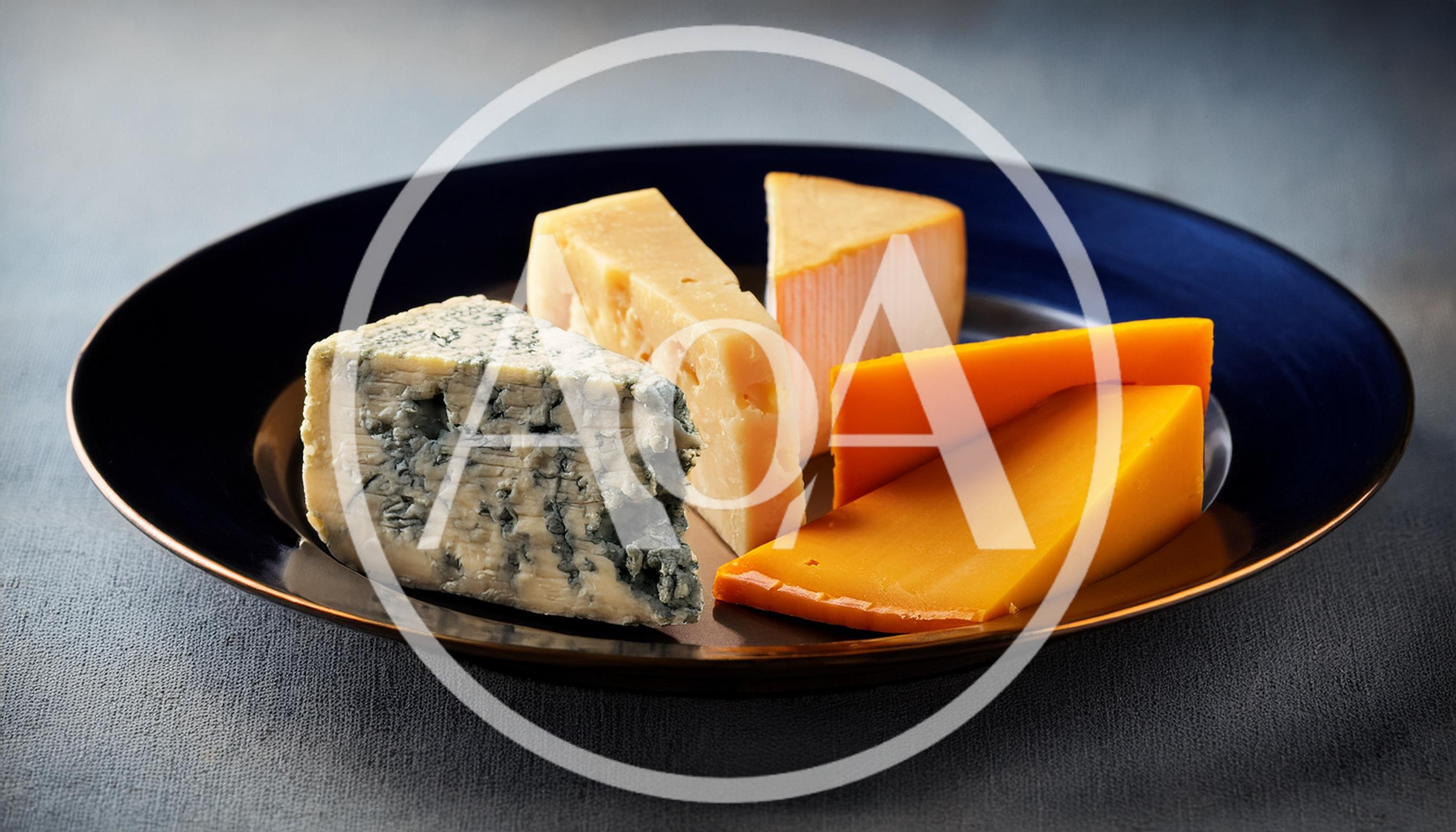 Assorted Cheese Wedges Arranged on a Dark Plate