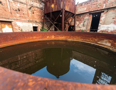 Abandoned Industrial Site With Rusty Metal Tank