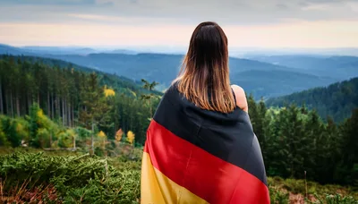 Woman Wrapped In German Flag Overlooking Mountain Landscape
