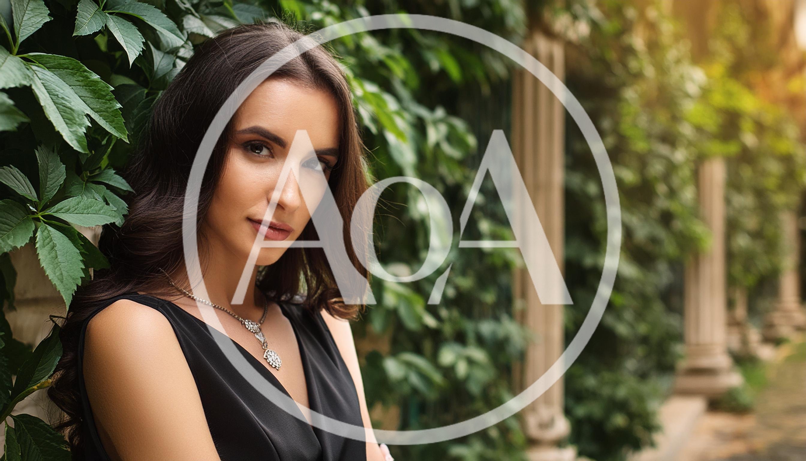 Elegant Woman Posing Beside Ivy Covered Stone Wall