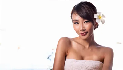 Beautiful Asian Woman With A Plumeria Flower In Hair