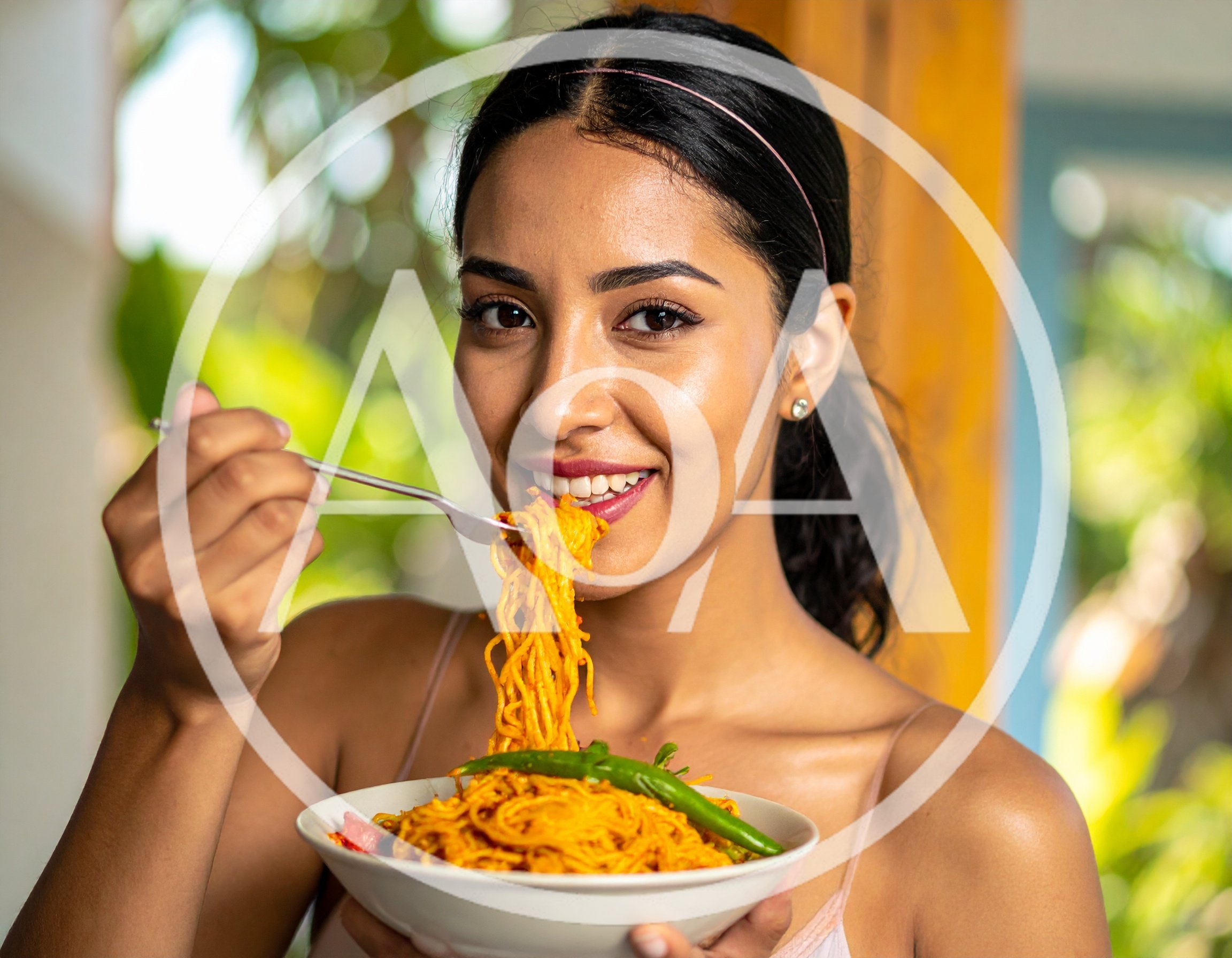 Young Woman Eating Spicy Noodles From A Bowl