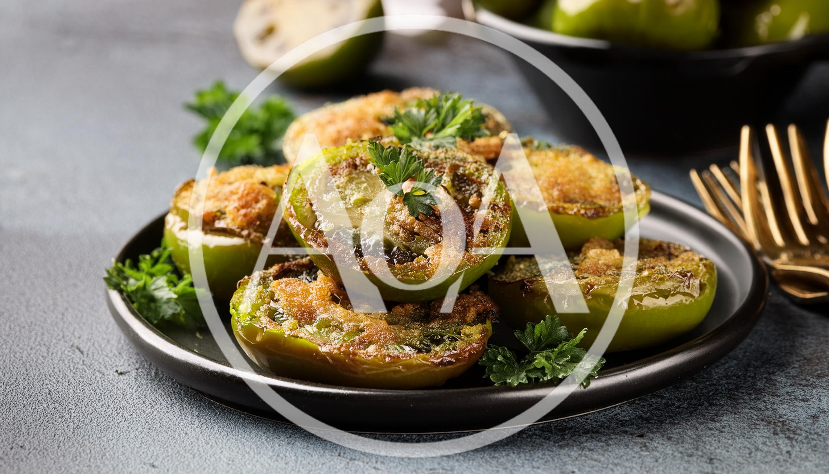 Baked Stuffed Green Tomatoes on a Black Plate