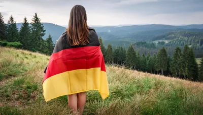 Woman Standing On Hillside Wrapped In German Flag