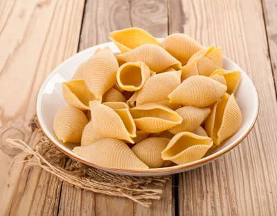 Raw Conchiglioni Pasta Shells In A White Bowl