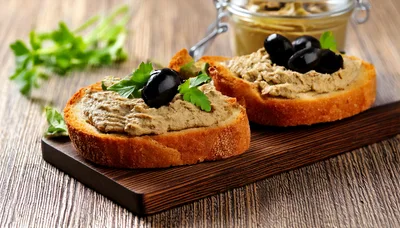 Two Slices Of Toasted Bread With Pate And Olives
