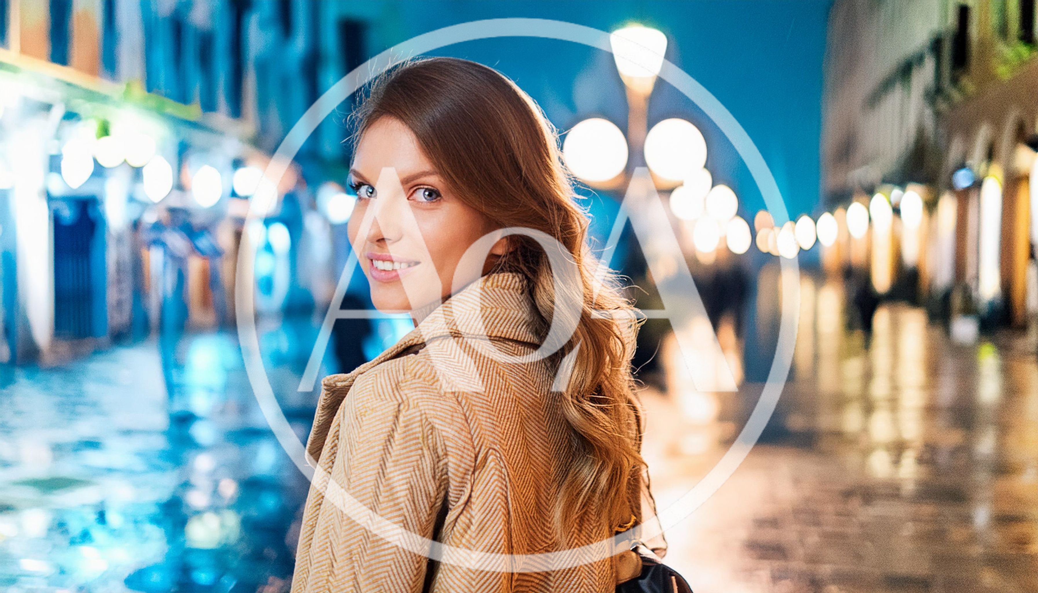 Young Woman Walking Through Illuminated City Street At Night