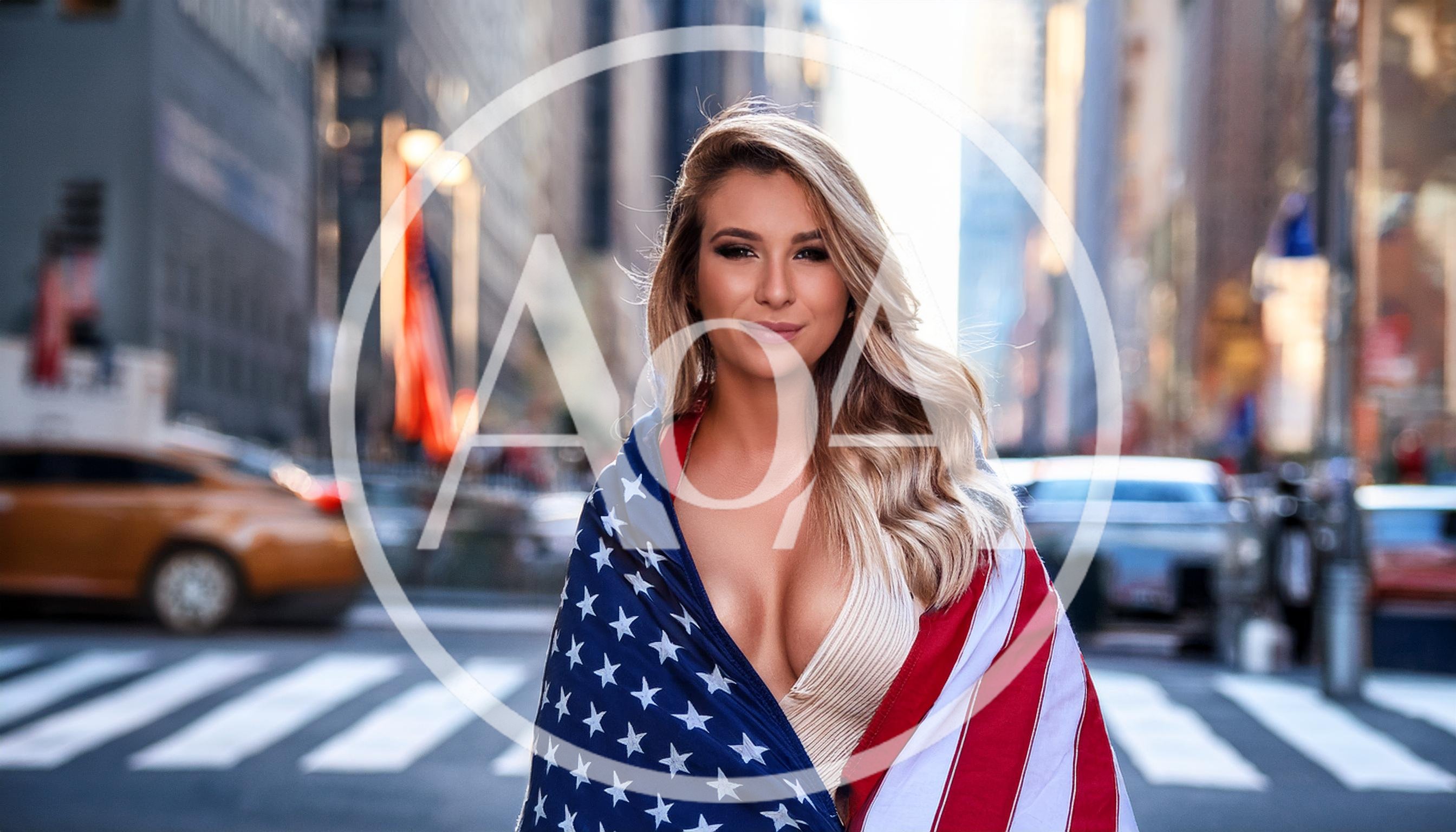Beautiful Woman Wrapped In American Flag On City Street