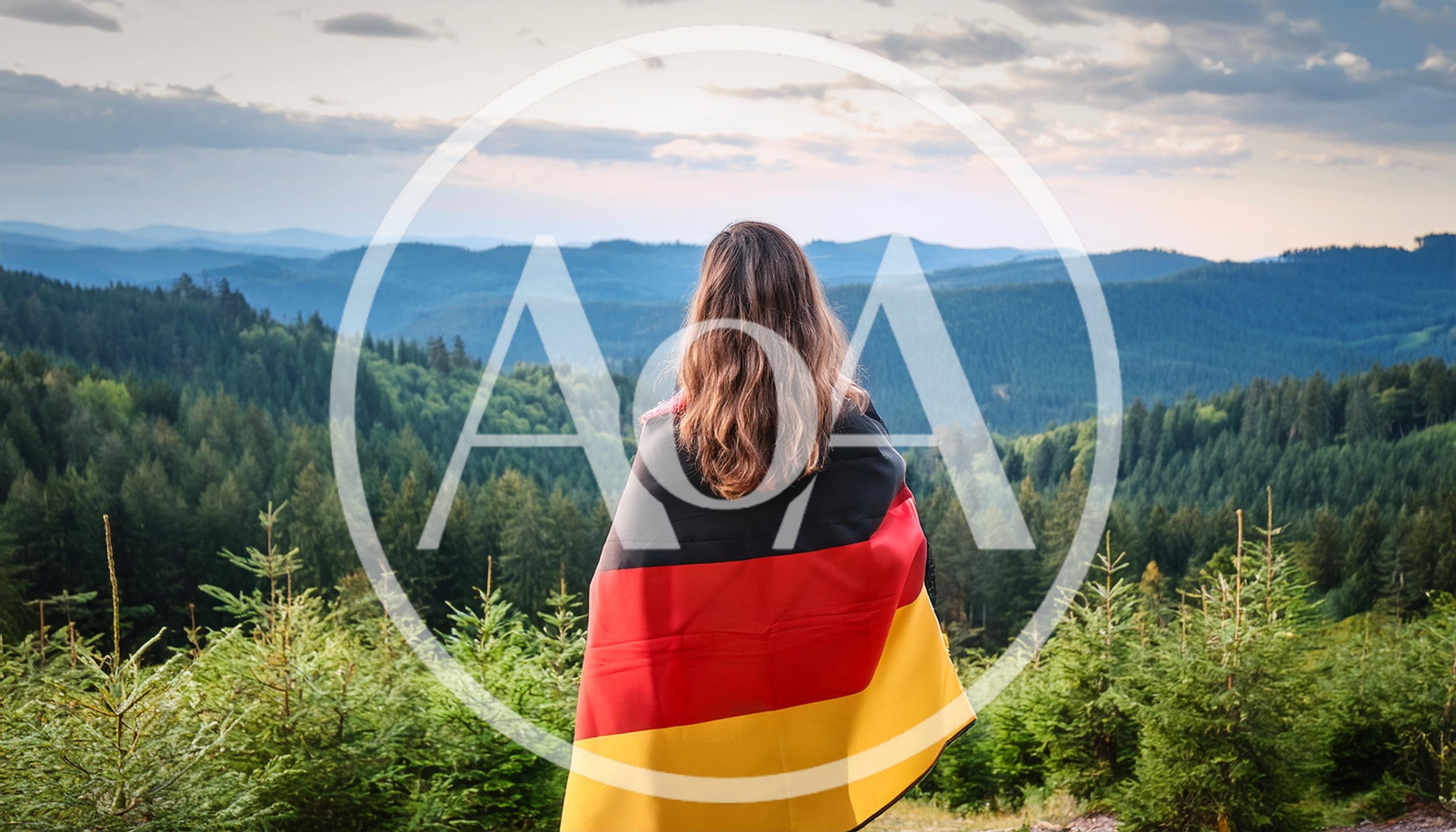 Woman Standing With German Flag Overlooking Forested Mountains