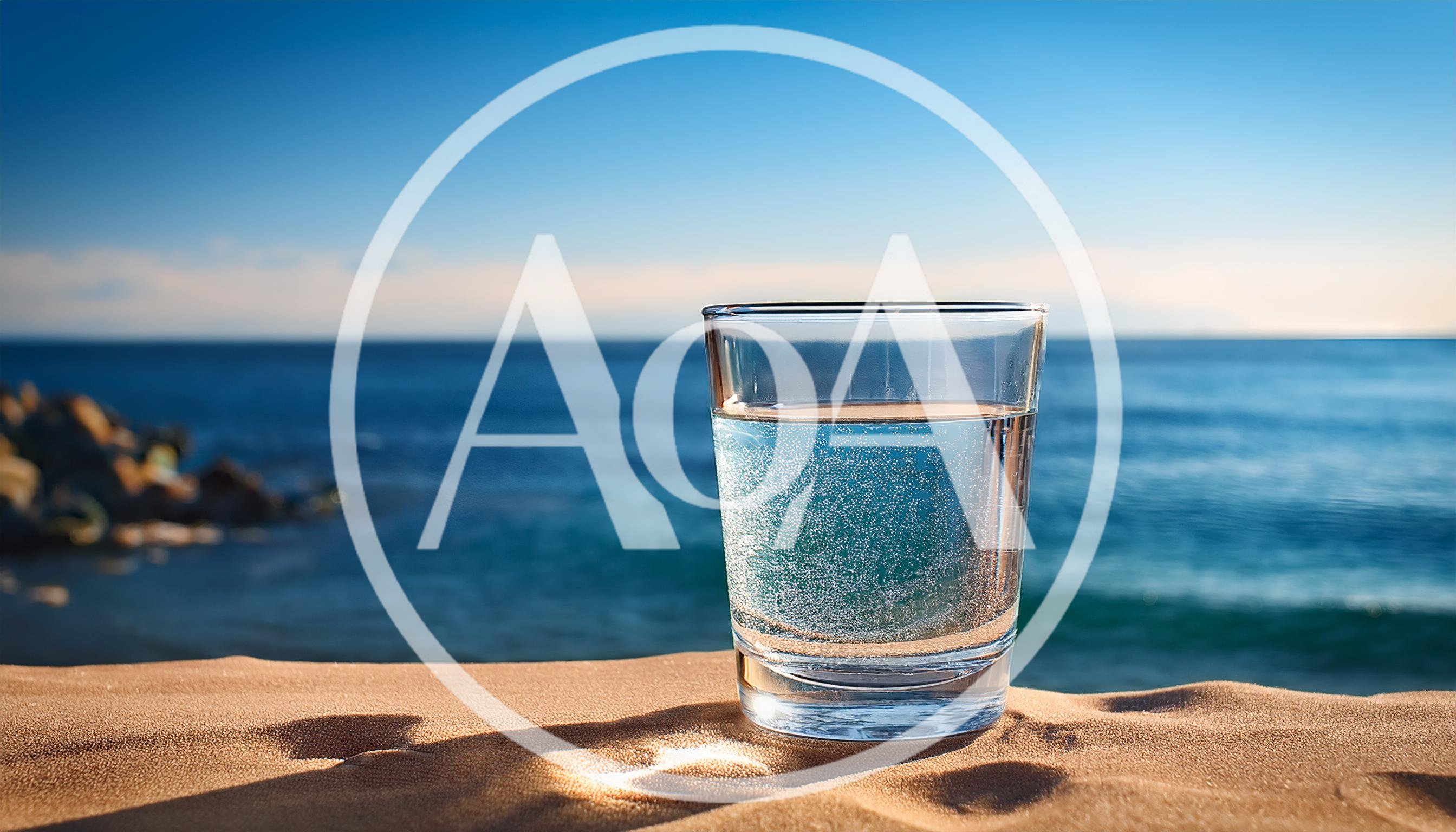Glass Of Sparkling Water On Sandy Beach