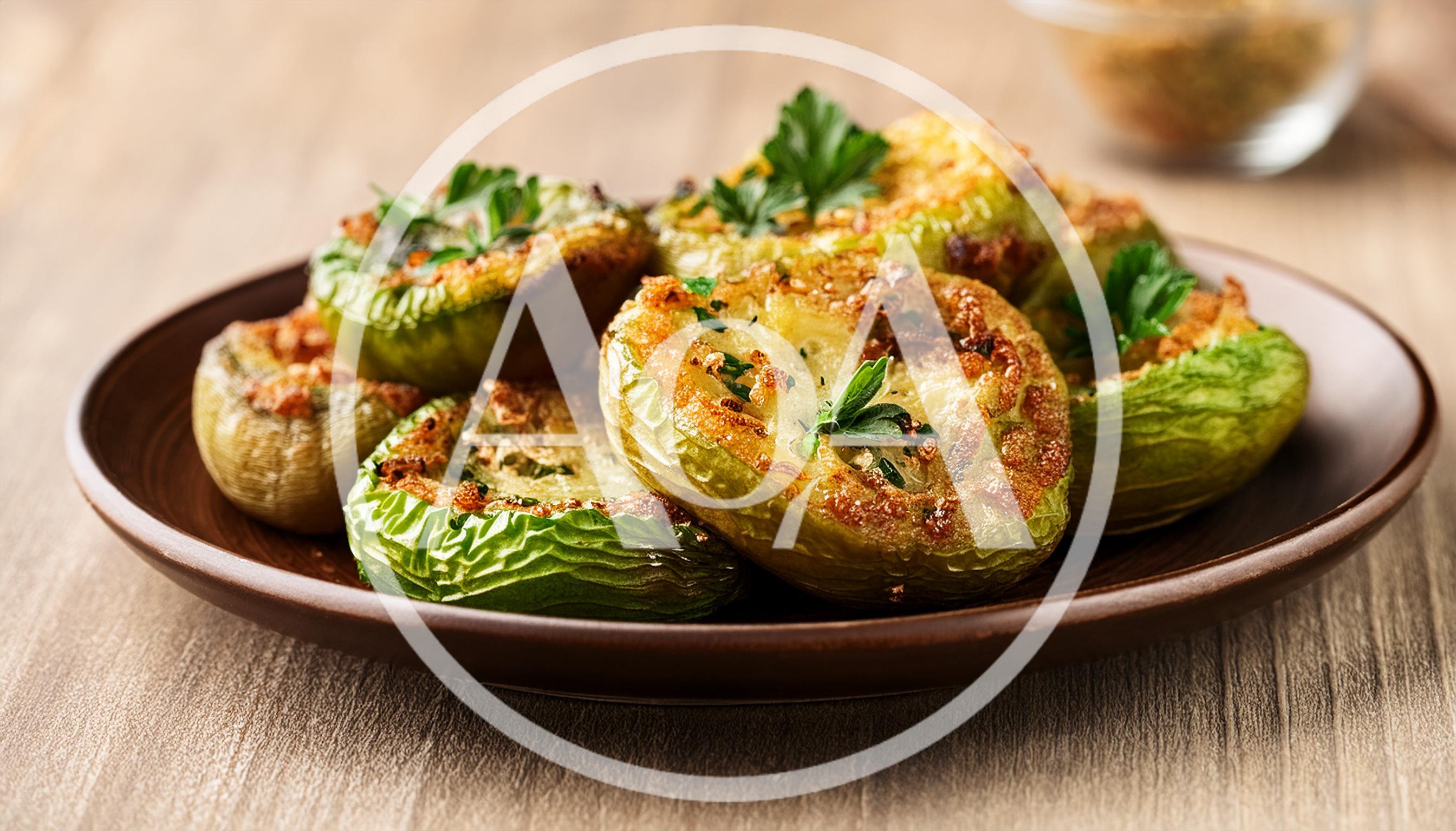 Roasted Stuffed Green Tomatoes On A Brown Plate