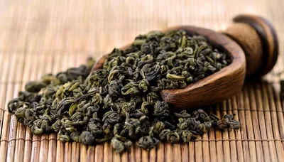 Dried Green Tea Leaves In A Wooden Scoop