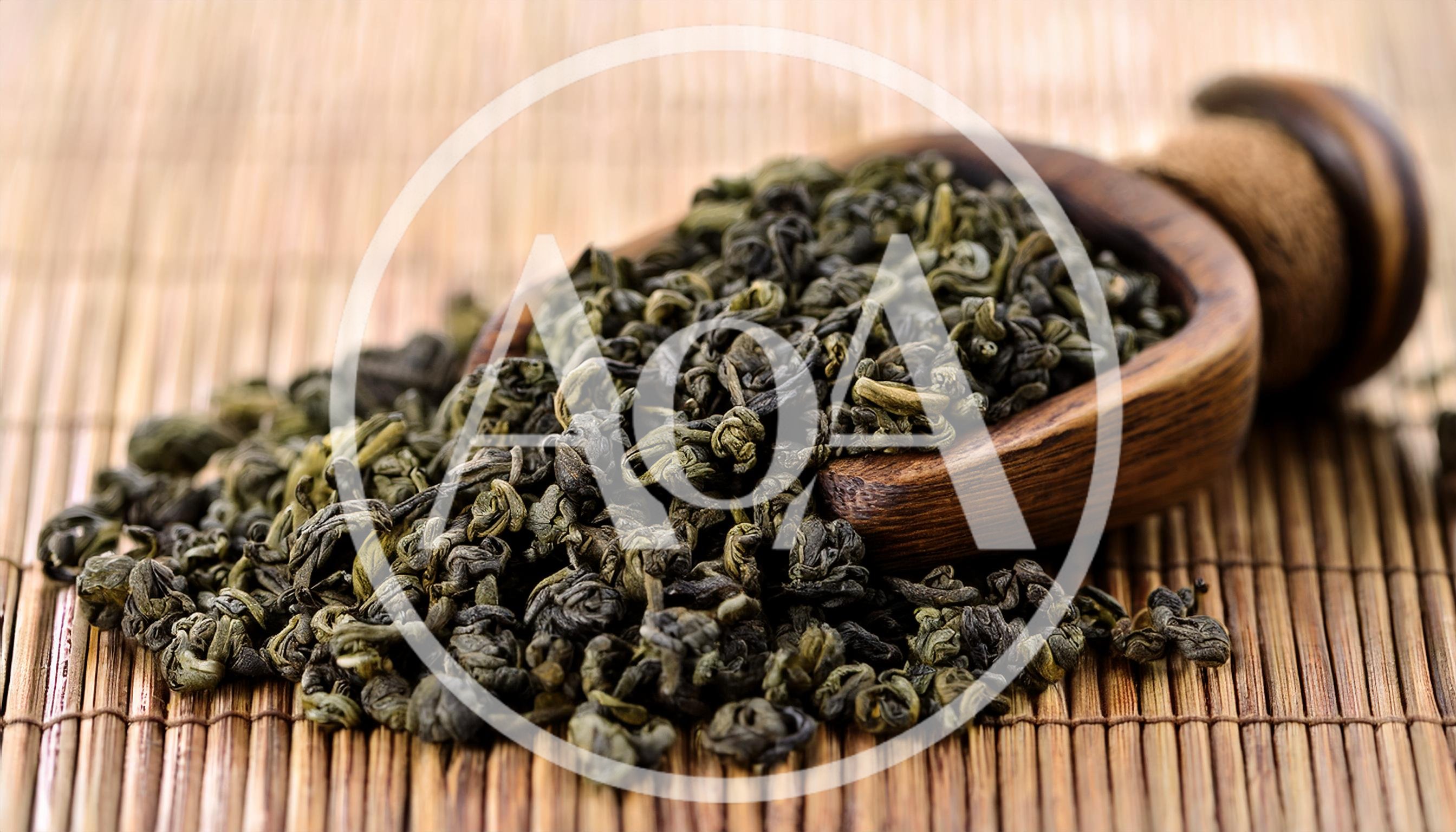 Dried Green Tea Leaves In A Wooden Scoop