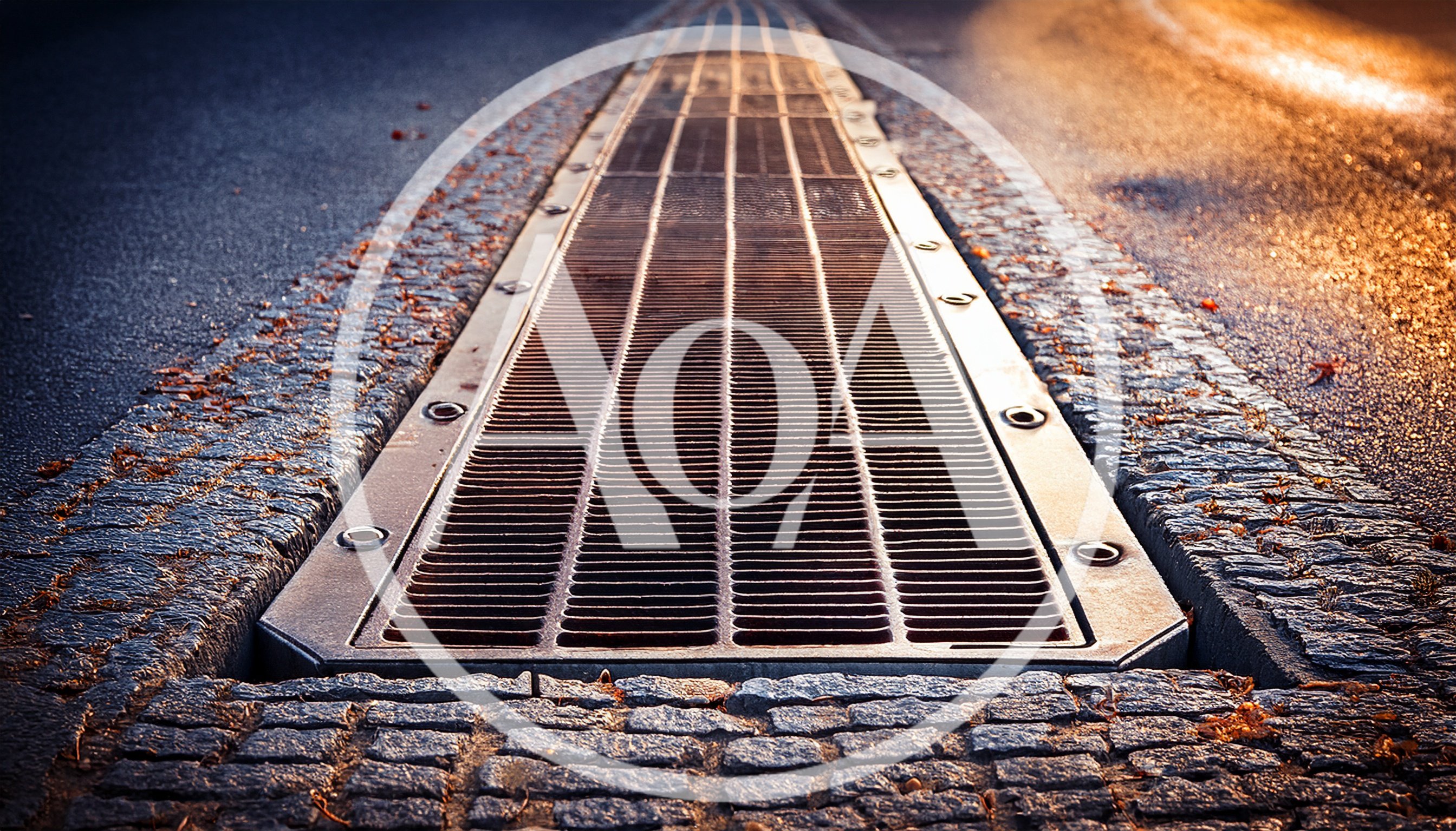Metal Drainage Grate Embedded in Cobblestone Street