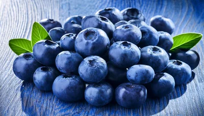 Fresh Blueberries With Green Leaves On Blue Wood