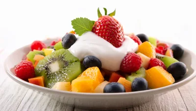 Fresh Fruit Salad With Cream And Mint Garnish