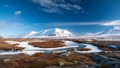 Snow Covered Mountains And Winding River In Arctic Landscape