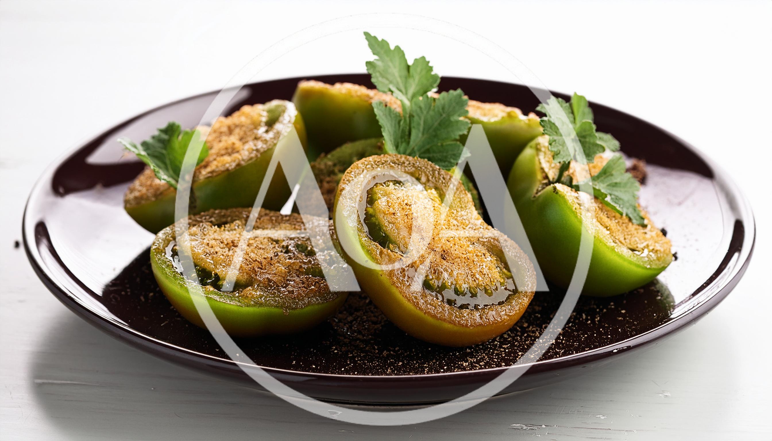 Roasted Green Tomato Halves on a Dark Plate