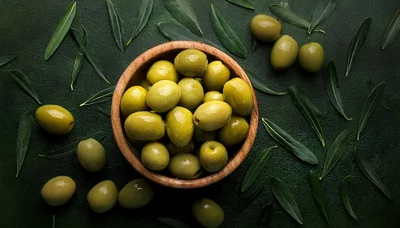 Green Olives In A Wooden Bowl With Leaves