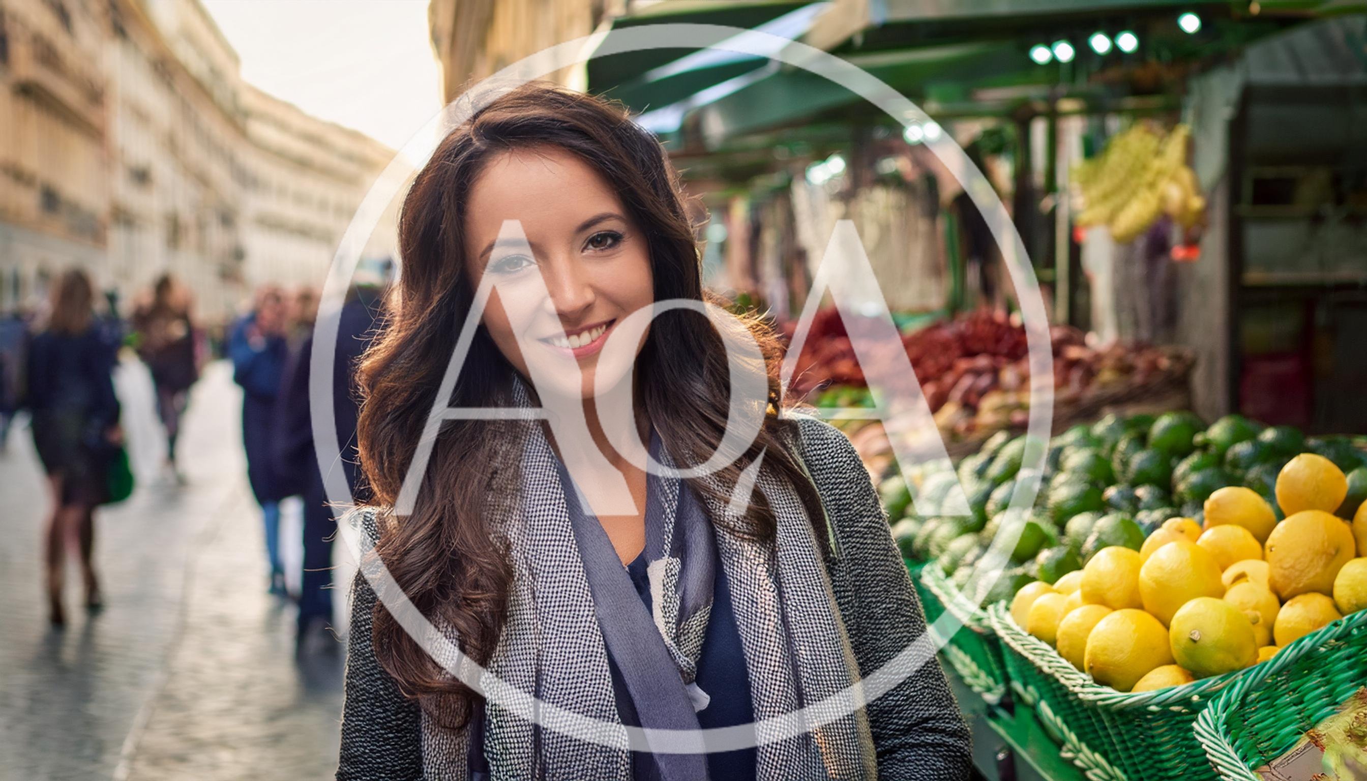 Smiling Woman Standing At An Outdoor Fruit Market