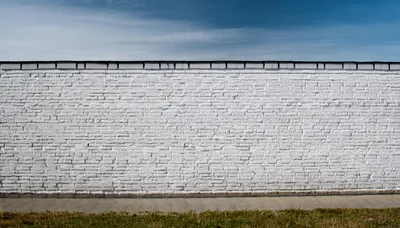 White Painted Brick Wall Against Blue Sky