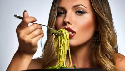 Beautiful Woman Eating Pesto Pasta With A Fork