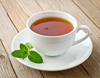 White Cup Of Tea With Fresh Mint Leaves