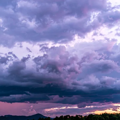 Dramatic Purple Sunset Clouds Over Mountain Silhouette