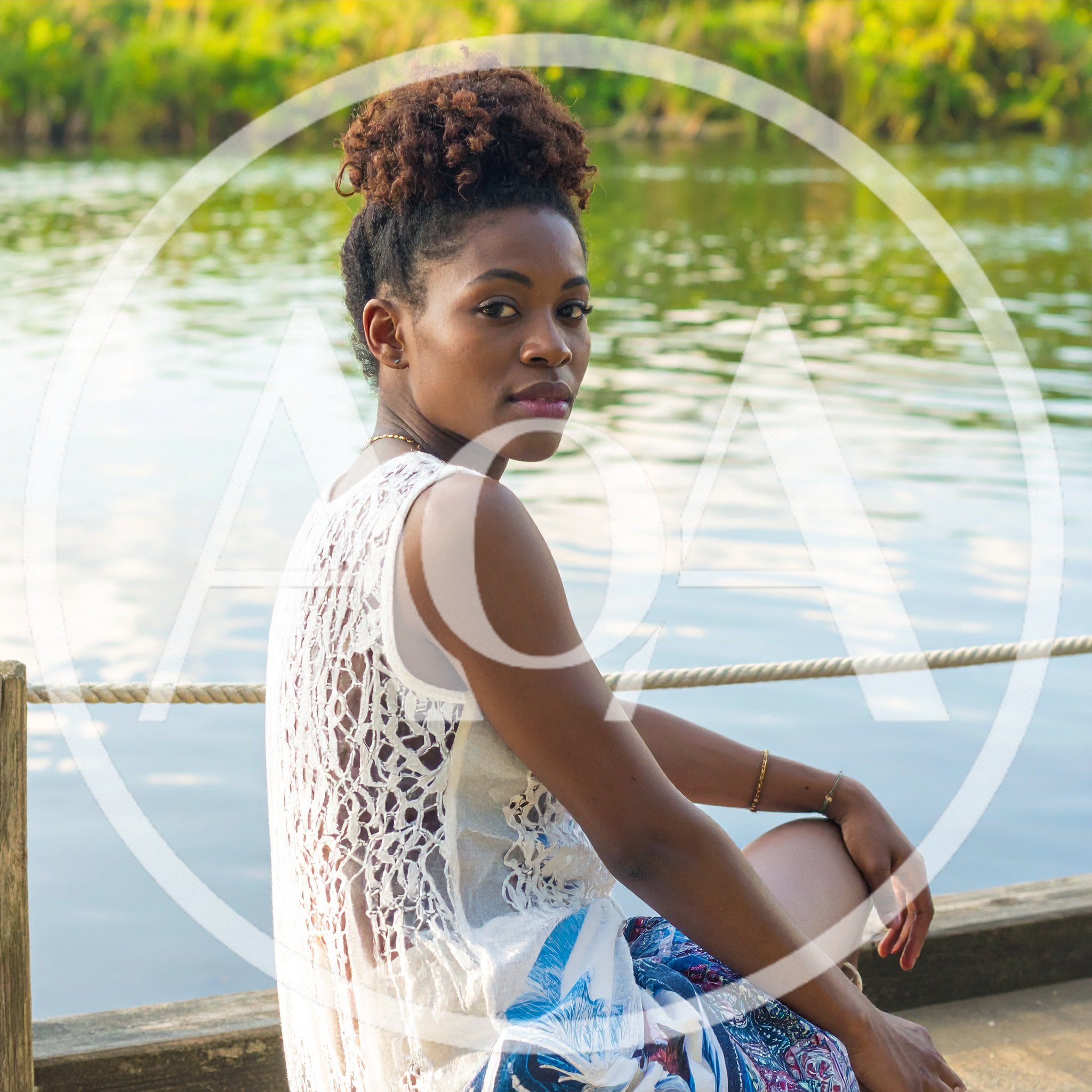 Young Woman Sitting On A Wooden Dock By The River