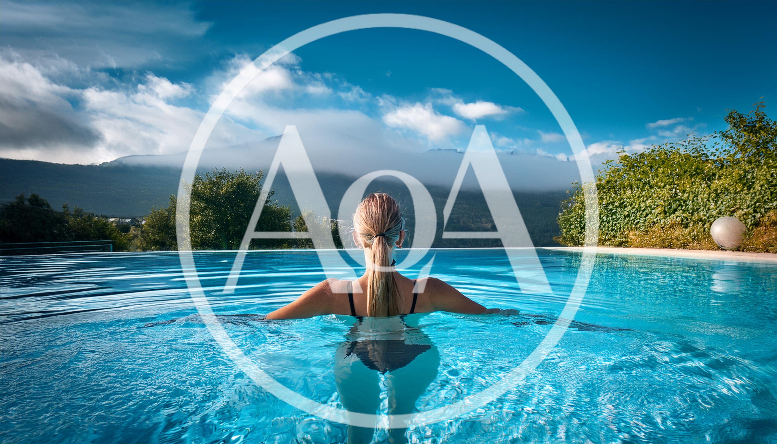 Woman Relaxing In Infinity Pool With Mountain View