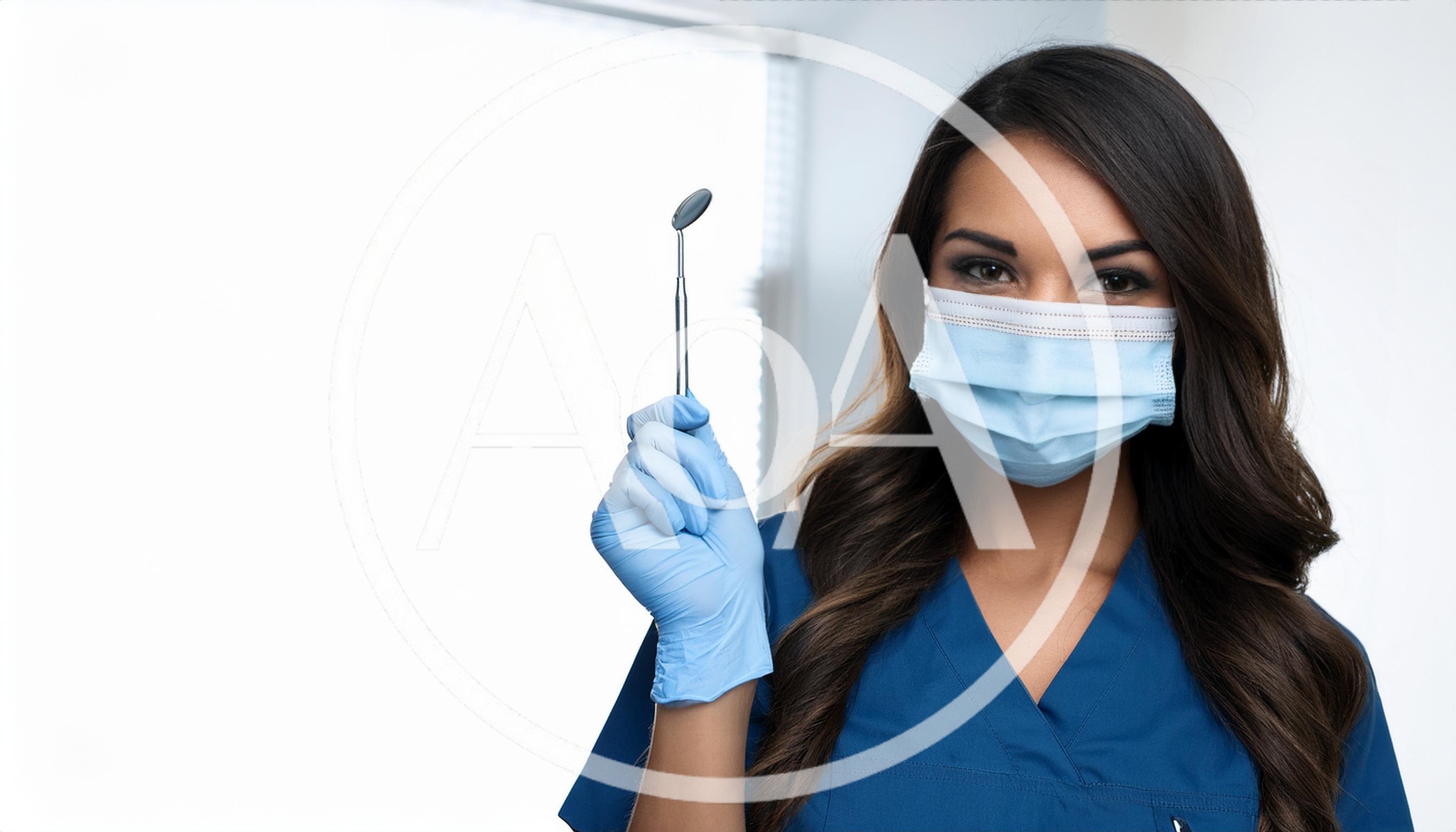 Female Dentist Holding Dental Mirror In Clinic