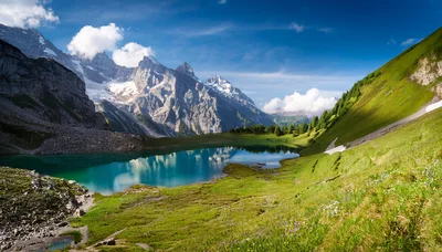 Alpine Lake Surrounded By Snow Capped Mountains