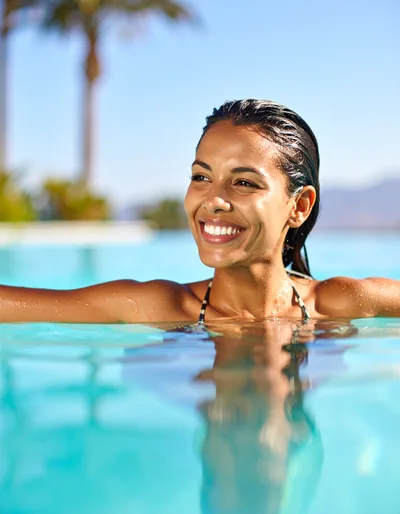 Smiling Woman Relaxing In A Sunny Outdoor Swimming Pool
