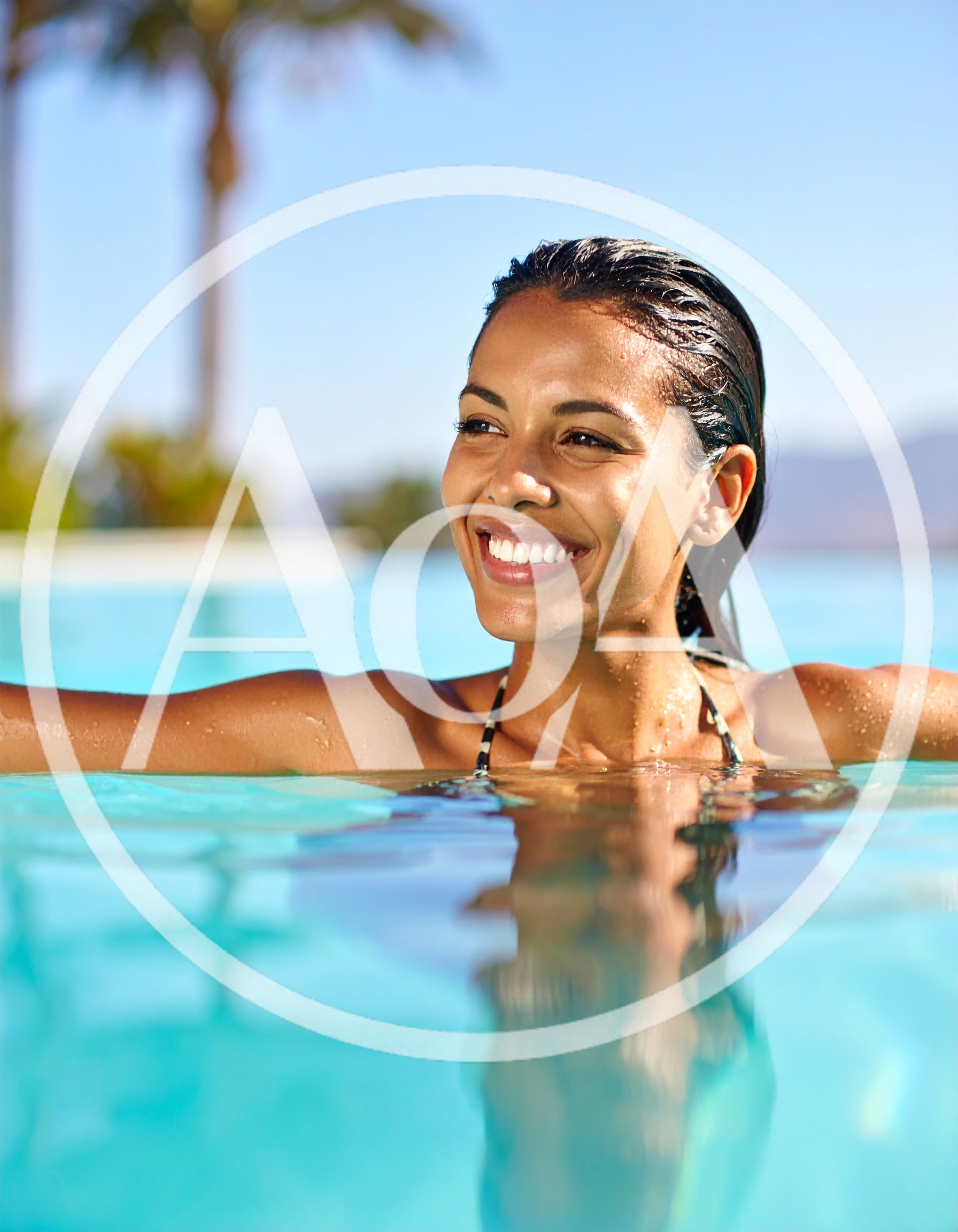 Smiling Woman Relaxing In A Sunny Outdoor Swimming Pool