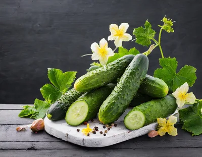 Fresh Cucumbers With Flowers On A Wooden Board