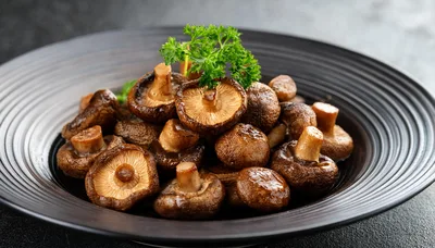 Braised Shiitake Mushrooms Served On A Black Plate