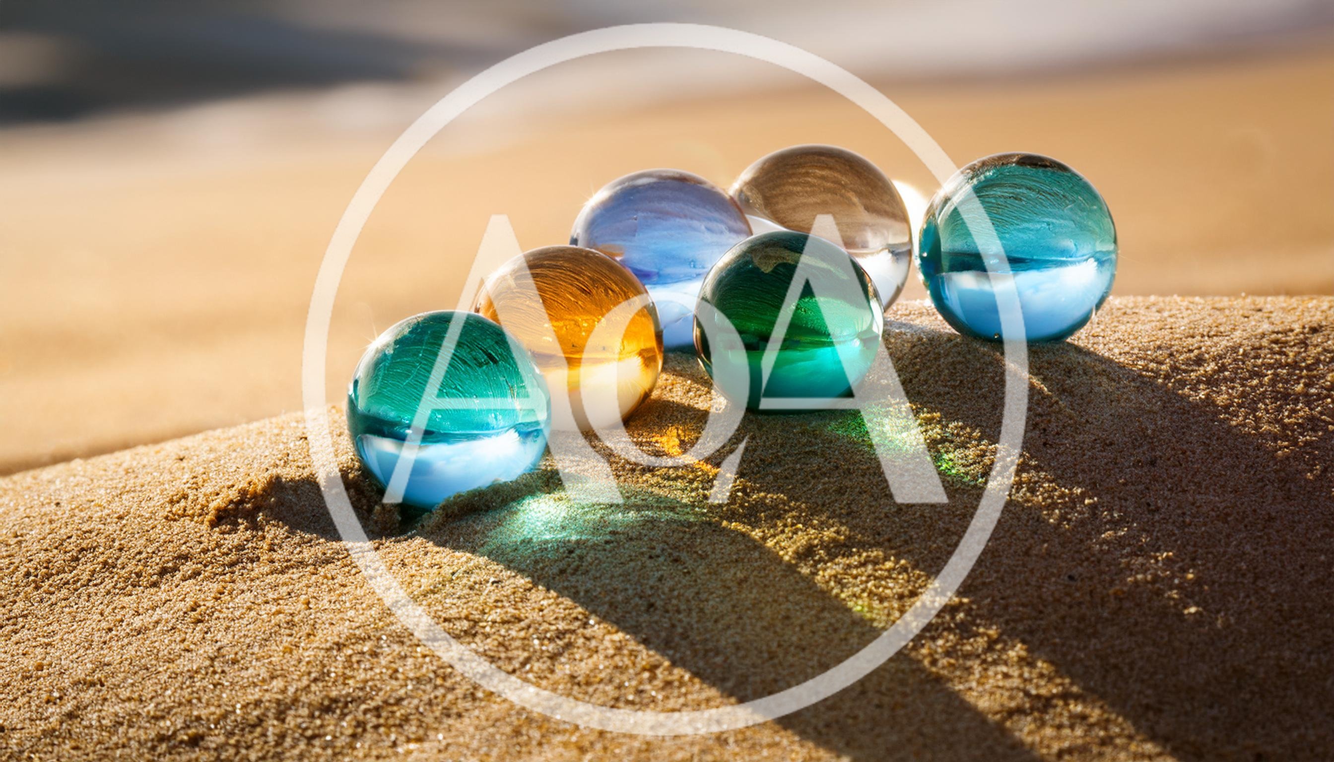 Colorful Glass Marbles Resting On Sandy Beach Dune