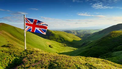 Union Jack Flag Flying Over Rolling Green Hills
