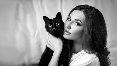 Beautiful Woman Holding A Black Cat In Studio
