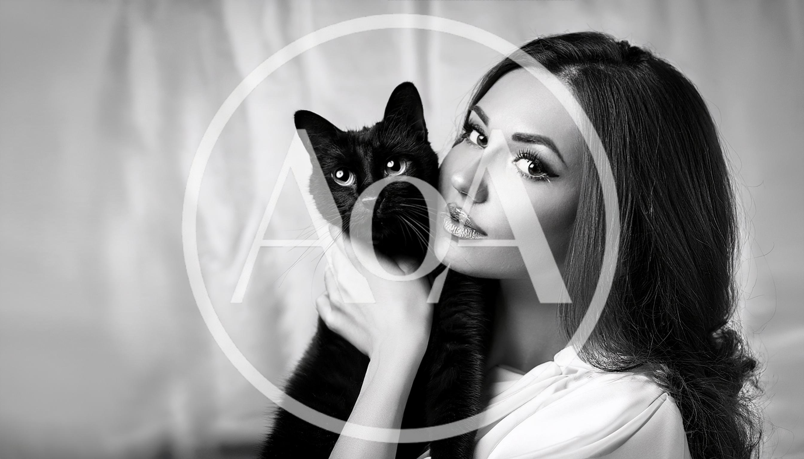Beautiful Woman Holding A Black Cat In Studio