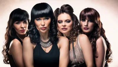 Four Glamorous Women Posing Together In Studio