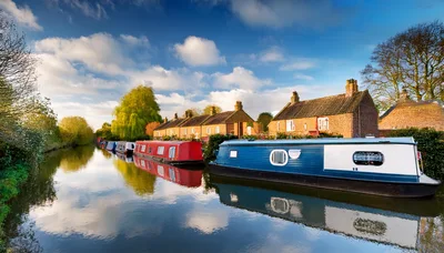 Narrowboats Moored Along A Canal In The English Countryside