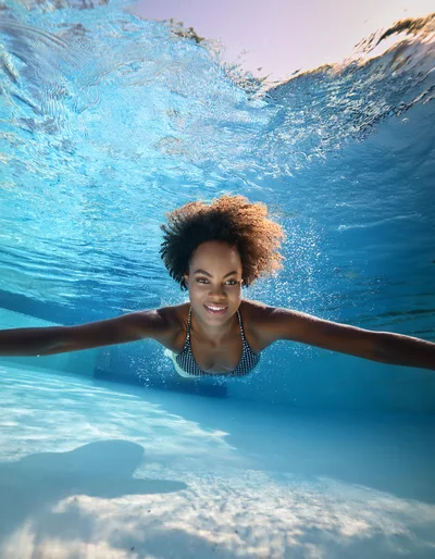 Young Woman Swimming Underwater In A Pool