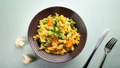 Bowl Of Creamy Vegetable Pasta With Cutlery